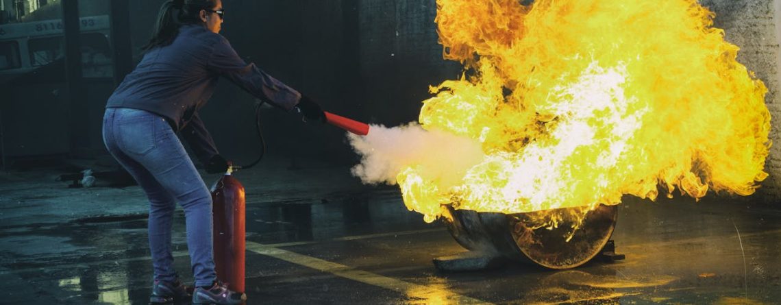 Femeie stingand incendiu. img reprezentativ pentru articol Ce trebuie să știi despre stingătoare de incendiu în 2025?